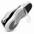 Ultimate Sole Protectors clear film being peeled off the outsole of a white and black sneaker on a white background