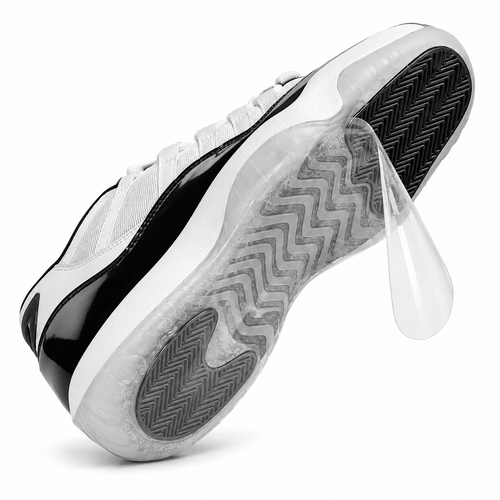 Ultimate Sole Protectors clear film being peeled off the outsole of a white and black sneaker on a white background