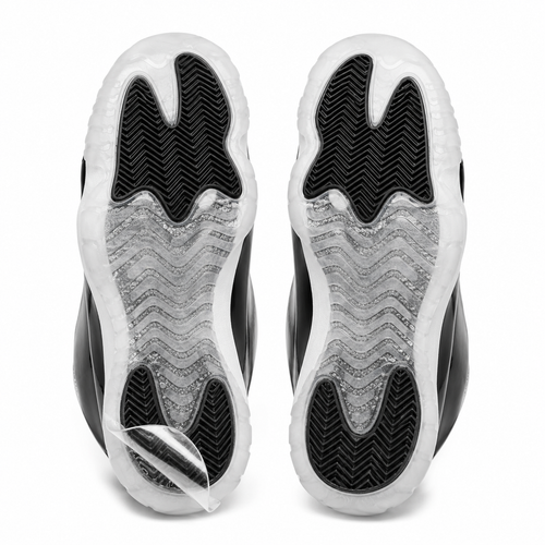 Pair of sneaker outsoles with Ultimate Sole Protectors clear film applied, one corner lifted to show the film peeling away cleanly